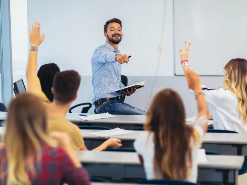 Male teacher engaging with students in a lively classroom discussion